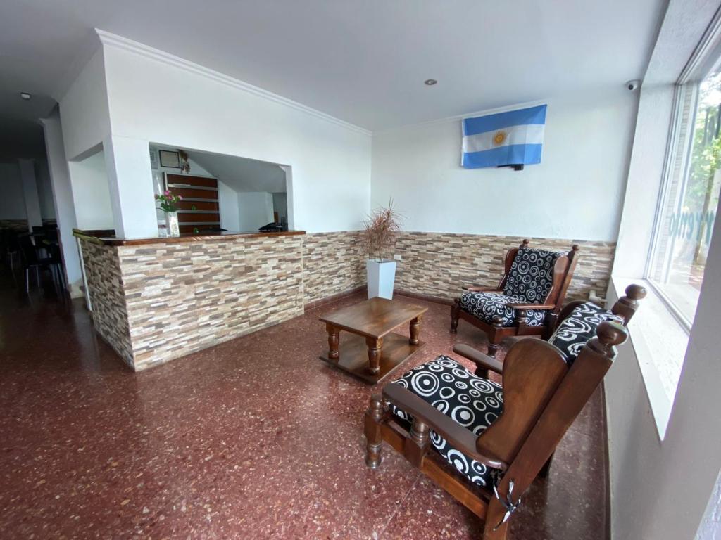 a living room with two chairs and a fireplace at Hotel Di Sorrento in Mar del Plata