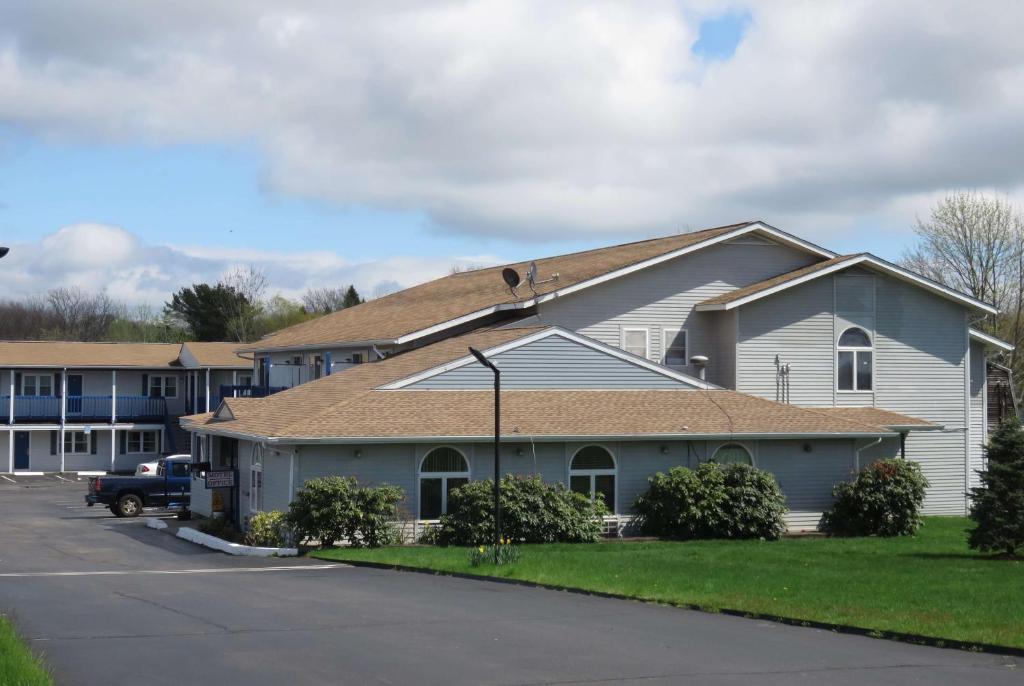a white house with a brown roof at Days Inn by Wyndham Middletown/Newport Area in Middletown