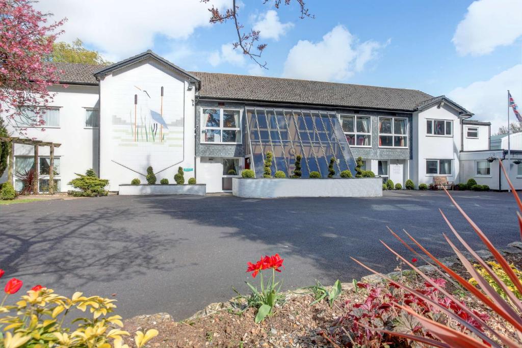 a house with a driveway in front of it at Best Western Premier Heronston Hotel & Spa in Bridgend