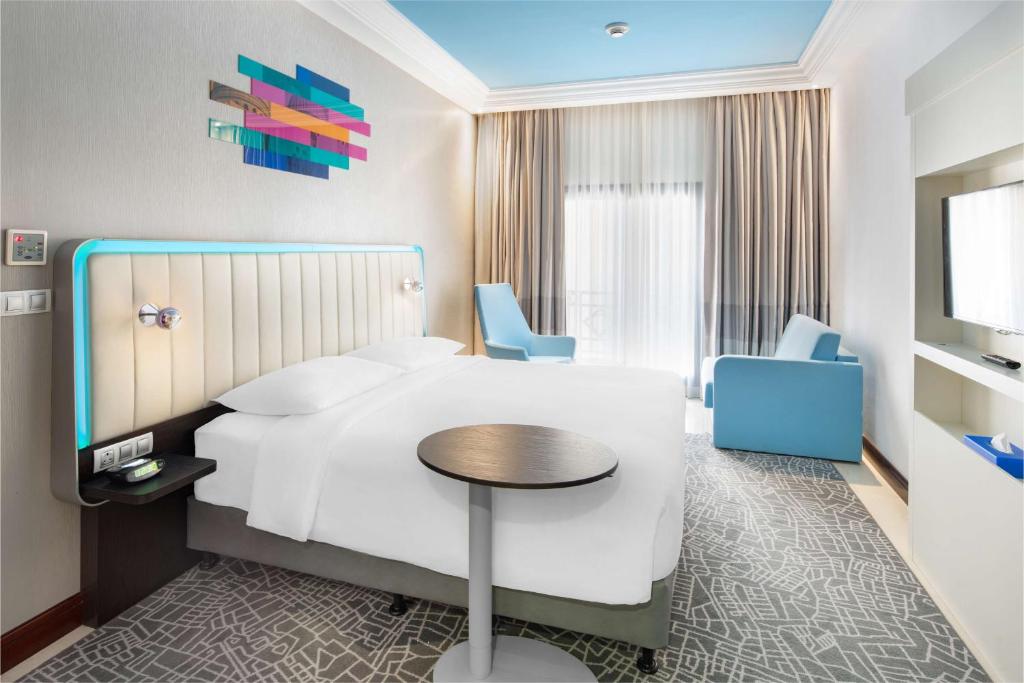 um quarto de hotel com uma cama, uma mesa e cadeiras em Park Inn by Radisson Makkah Al Naseem em Meca