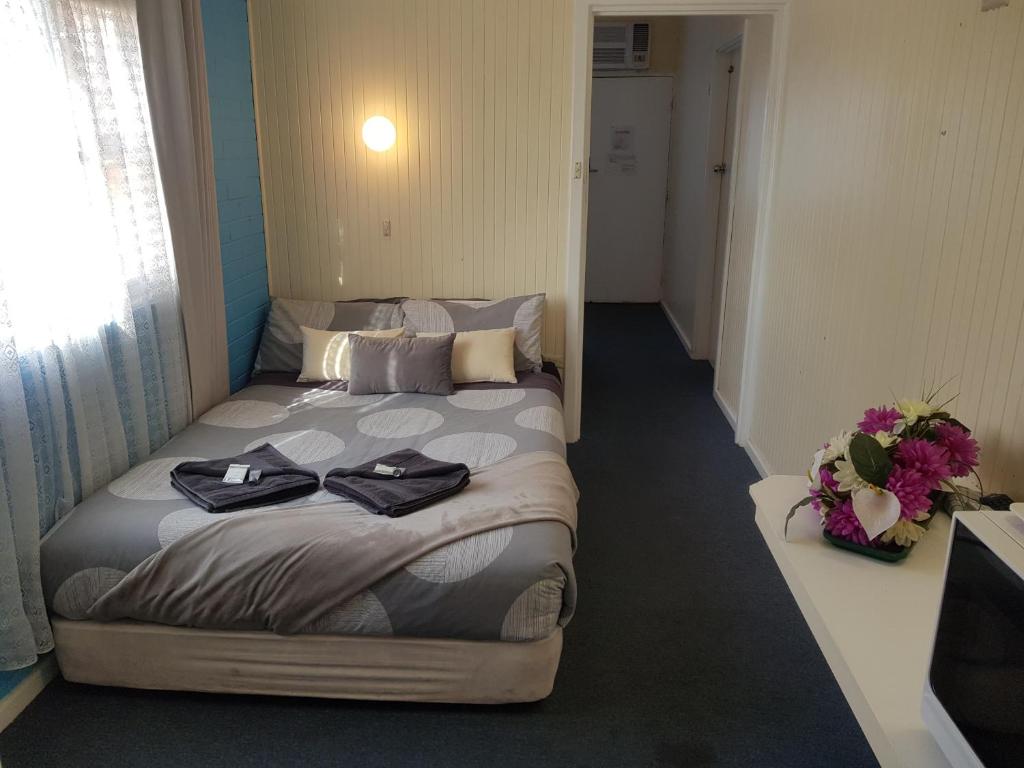 a bed with pillows and a blanket on top of it at Whyalla Country Inn Motel in Whyalla