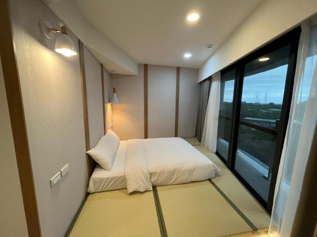 a small bedroom with a bed and a large window at Yawan Hotel in Wenquan