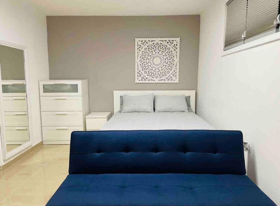 California Apartments في يابوكوا: أريكة زرقاء في غرفة نوم مع سرير