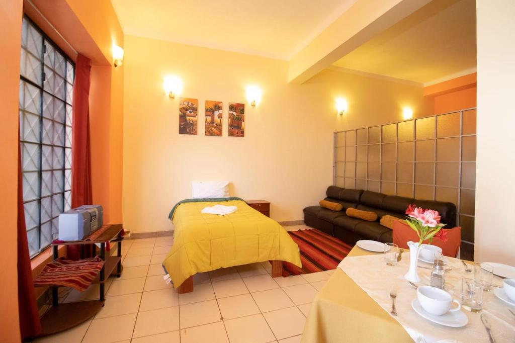 a living room with a couch and a yellow blanket at Apartment in the Plaza de Armas Cusco in Cusco