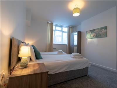 a bedroom with a bed and a lamp on a table at Lower Ashby Apartments in Scunthorpe