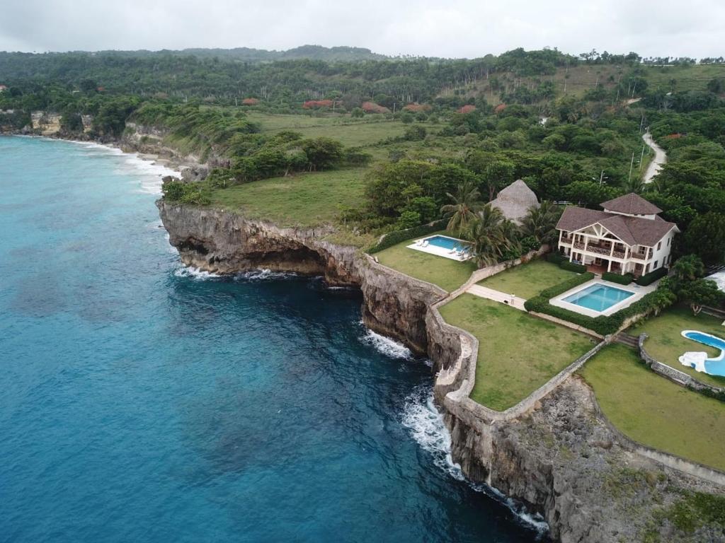 una vista aérea de una casa sobre un acantilado sobre el agua en hacienda del mar, en Río San Juan