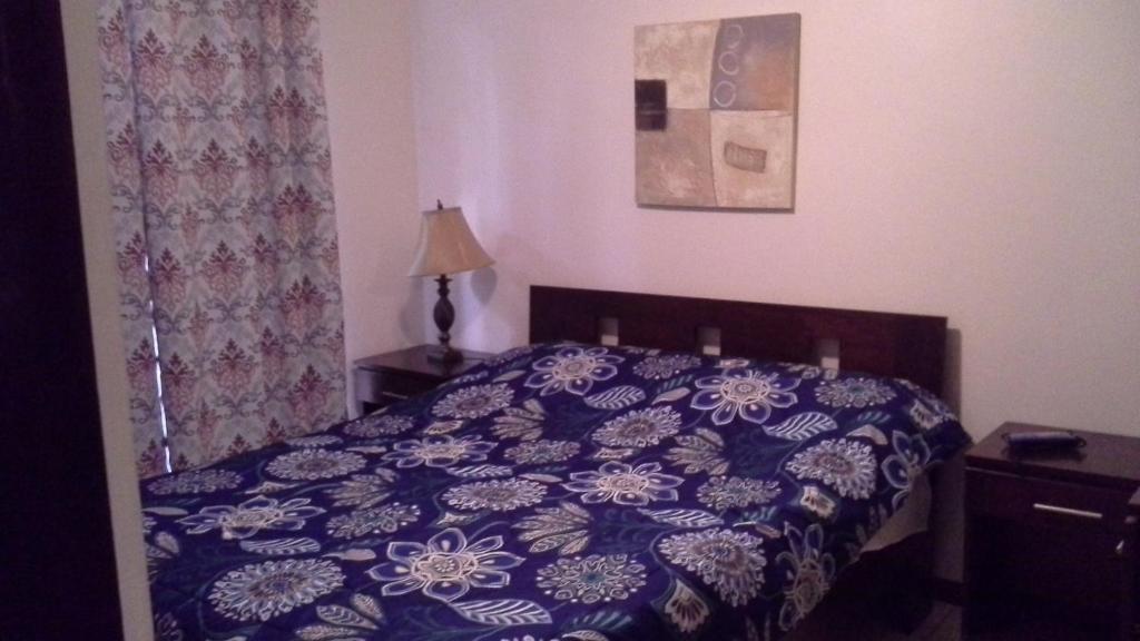 1 dormitorio con 1 cama con edredón azul en Room in Condo - Nice condo to vacation in Playas del Coco, en Coco