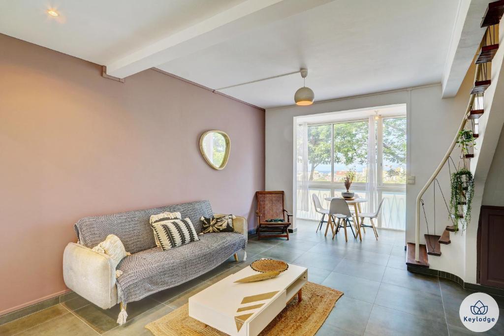 sala de estar con sofá y mesa en T3 - Duplex Moringue 2 étoiles - Vue sur Jardin - Proche centre Saint-Denis, en Saint-Denis