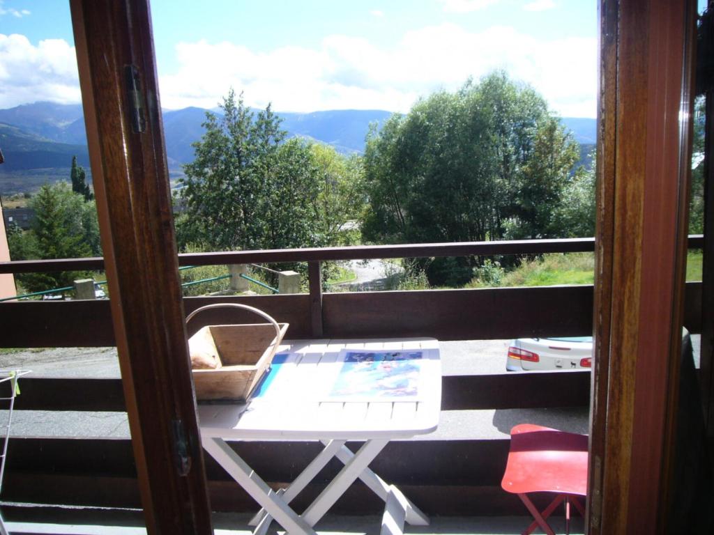 Habitación con vistas a un balcón con mesa y sillas. en Appartement 3 pièces 7 pers avec vue magnifique sur les Pyrénées 79268, en Font-Romeu-Odeillo-Via