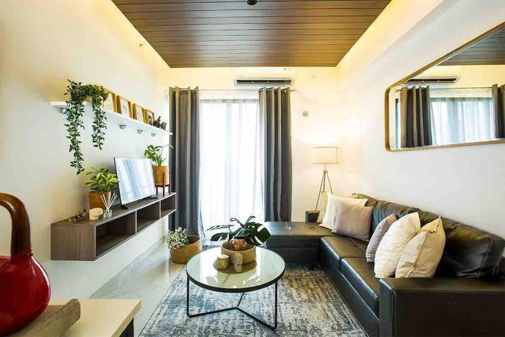 een woonkamer met een bank en een tafel bij NOCHE - 2 bedroom Skyhouse Apartment BSD in Tangerang