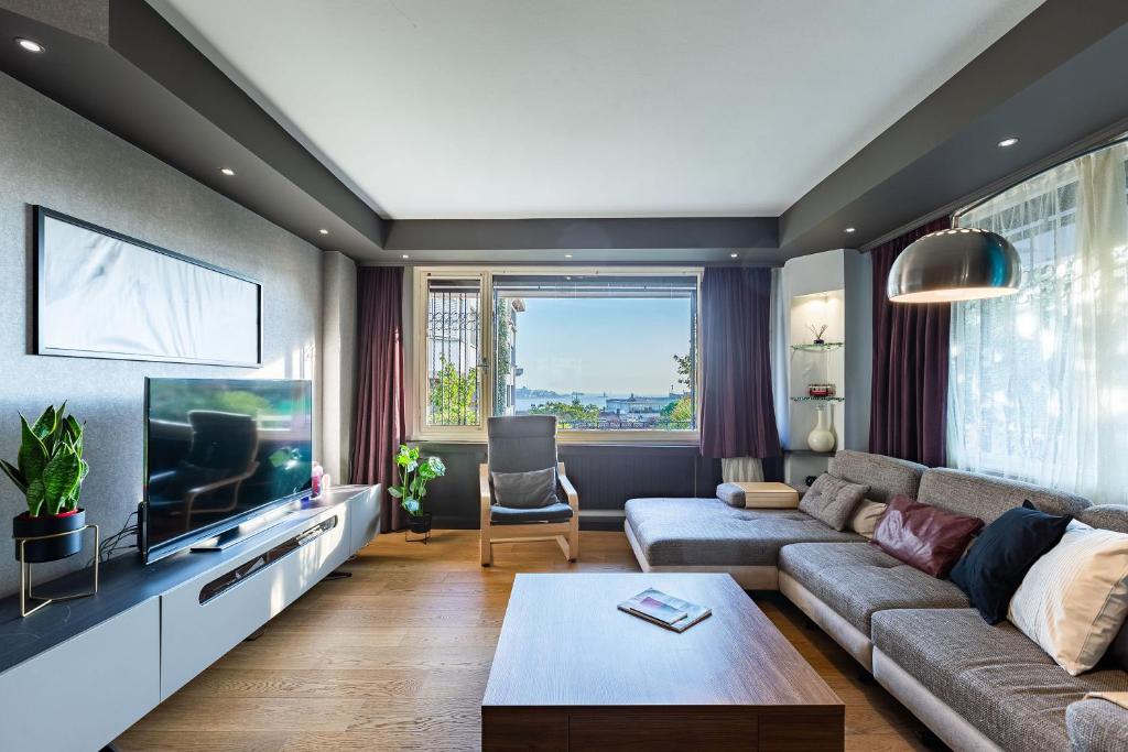 ein Wohnzimmer mit einem Sofa und einem TV in der Unterkunft with Fascinating Bosphorus View in Besiktas in Istanbul