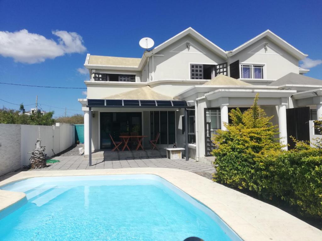 a house with a swimming pool in front of a house at Vanz Villa in Mont Choisy