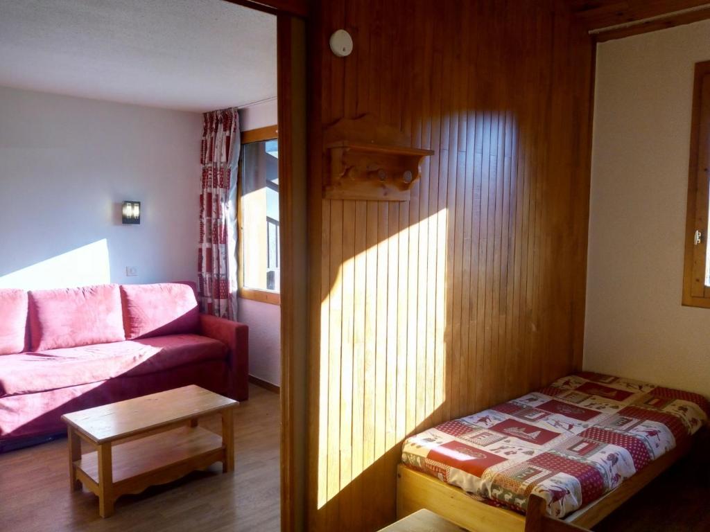 ein Wohnzimmer mit einem rosa Sofa und einem Tisch in der Unterkunft Appartement Méribel, 1 pièce, 4 personnes - FR-1-355-178 in Méribel