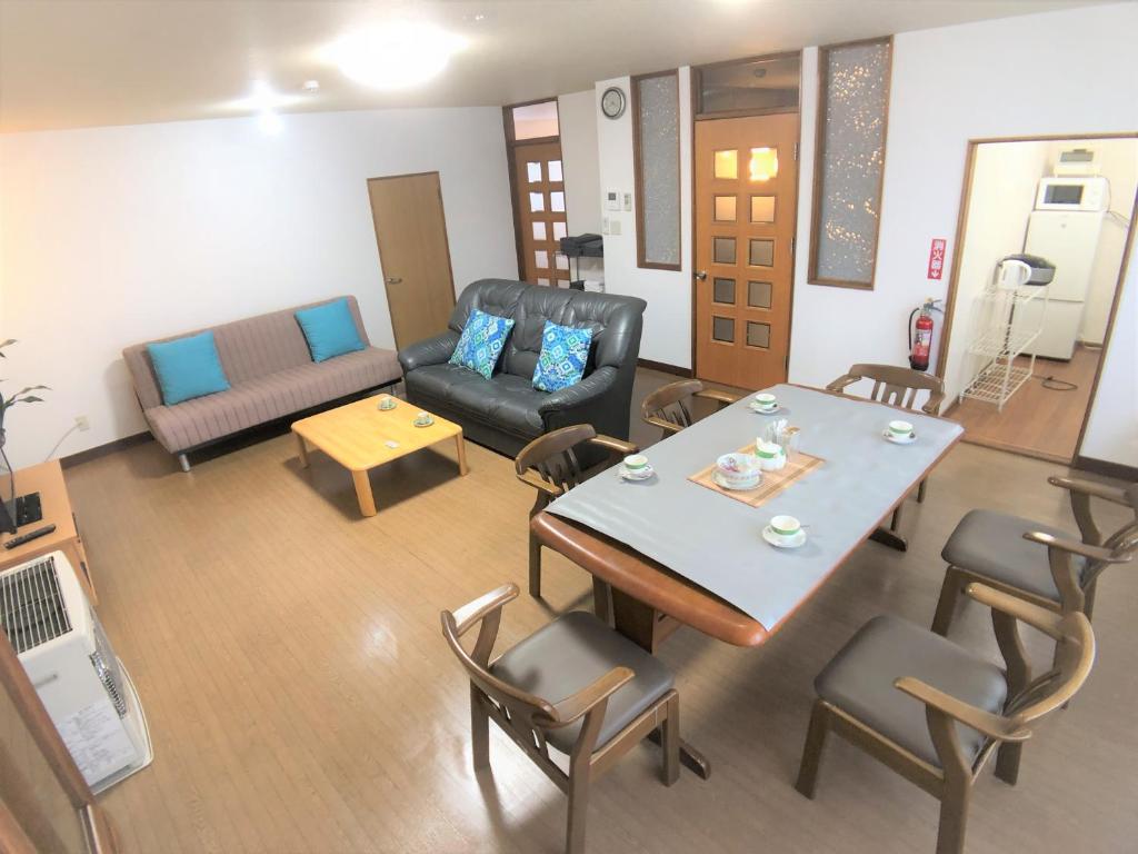 - un salon avec une table, des chaises et un canapé dans l'établissement STAY3‐11, à Asahikawa