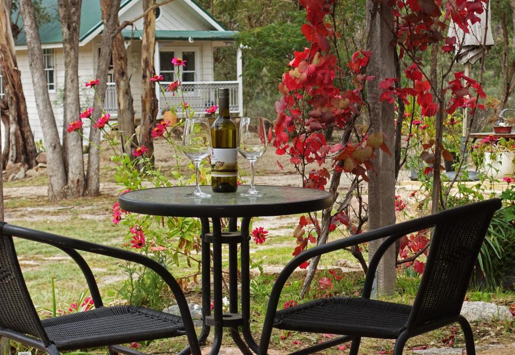 una mesa con 2 sillas y una botella de vino en Severn River Cottages, en Severnlea