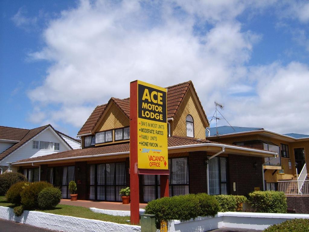 ein großes Haus mit einem Schild davor in der Unterkunft Ace Motor Lodge in Rotorua