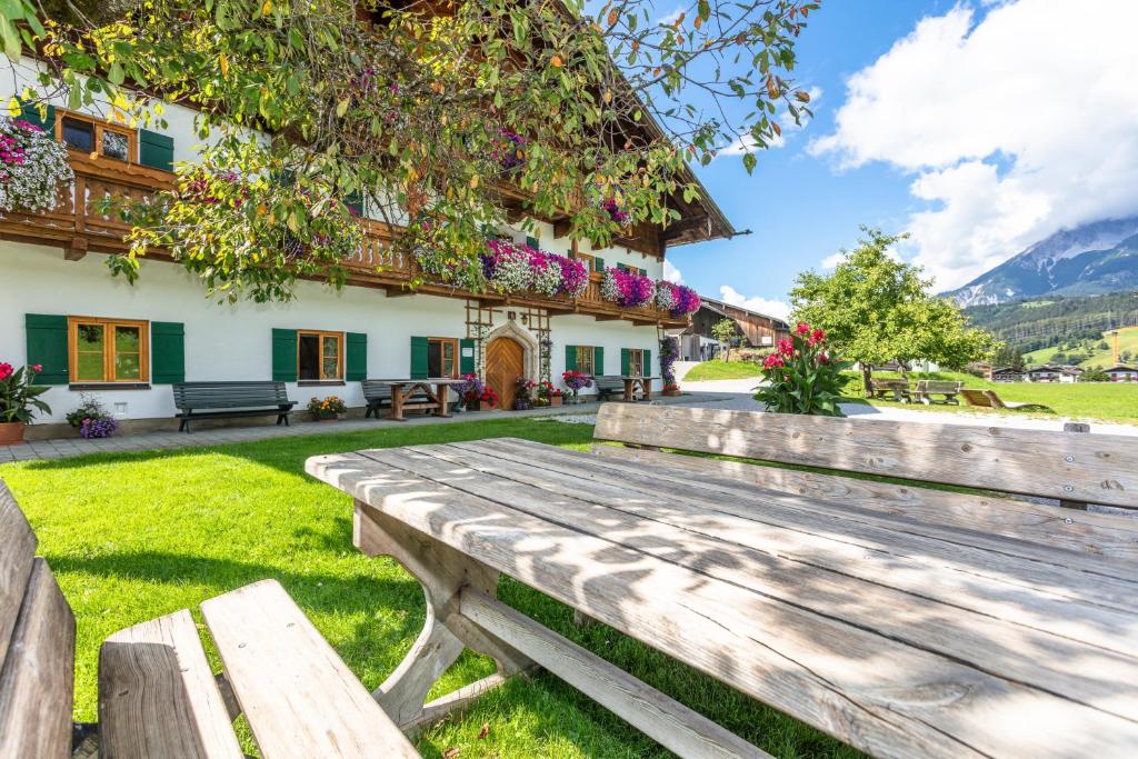 a wooden bench in front of a house at Biobauernhof Stegerbauer in Maria Alm am Steinernen Meer