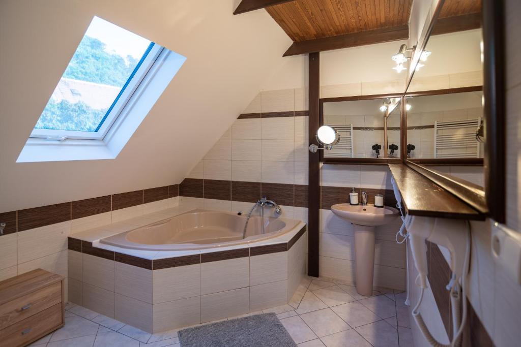 Łazienka na poddaszu z wanną i umywalką w obiekcie Mikulov - Inn - hotel s vinným sklepem Venuše w mieście Mikulov