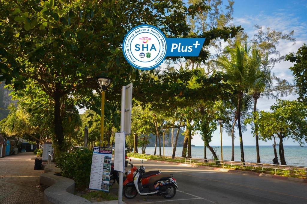 a scooter is parked next to a street sign at iRest Ao Nang Seafront - SHA Plus in Ao Nang Beach