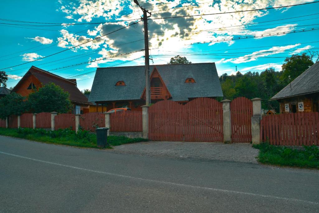 una casa con una recinzione rossa di Casa cu traditie a Sîrbi