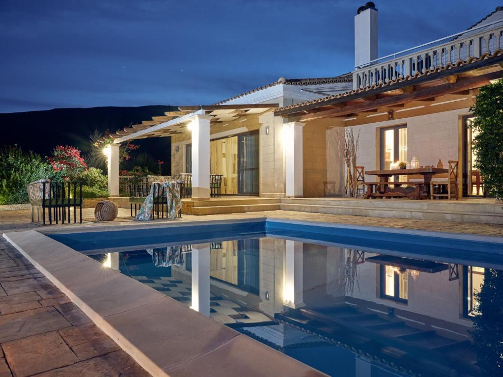 a house with a swimming pool in front of a house at Astarte Villas - The Villa in Olive Grove in Lagópodhon