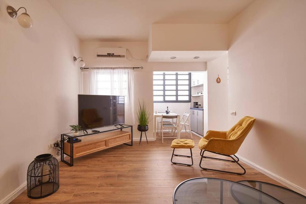 sala de estar con TV, sofá y mesa en Arnon APR Gordon area, en Tel Aviv