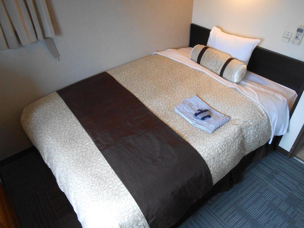 Postel nebo postele na pokoji v ubytování Kakegawa Station Hotel