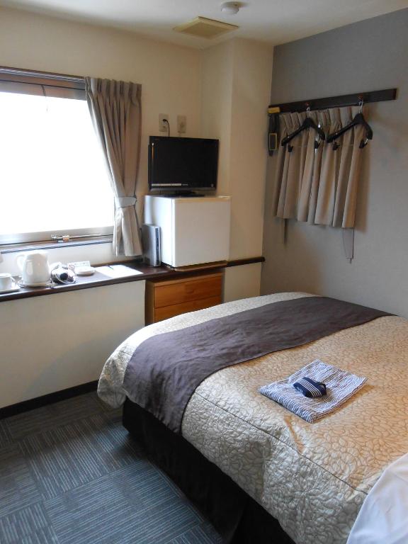 Postel nebo postele na pokoji v ubytování Kakegawa Station Hotel