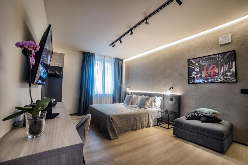 - une chambre avec un lit, une table et un canapé dans l'établissement Corso 84 Luxury Suites, à Pescara