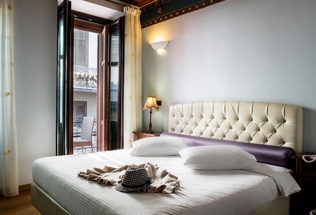 a bedroom with a large white bed with a white headboard at Kyveli Suites in Nafplio