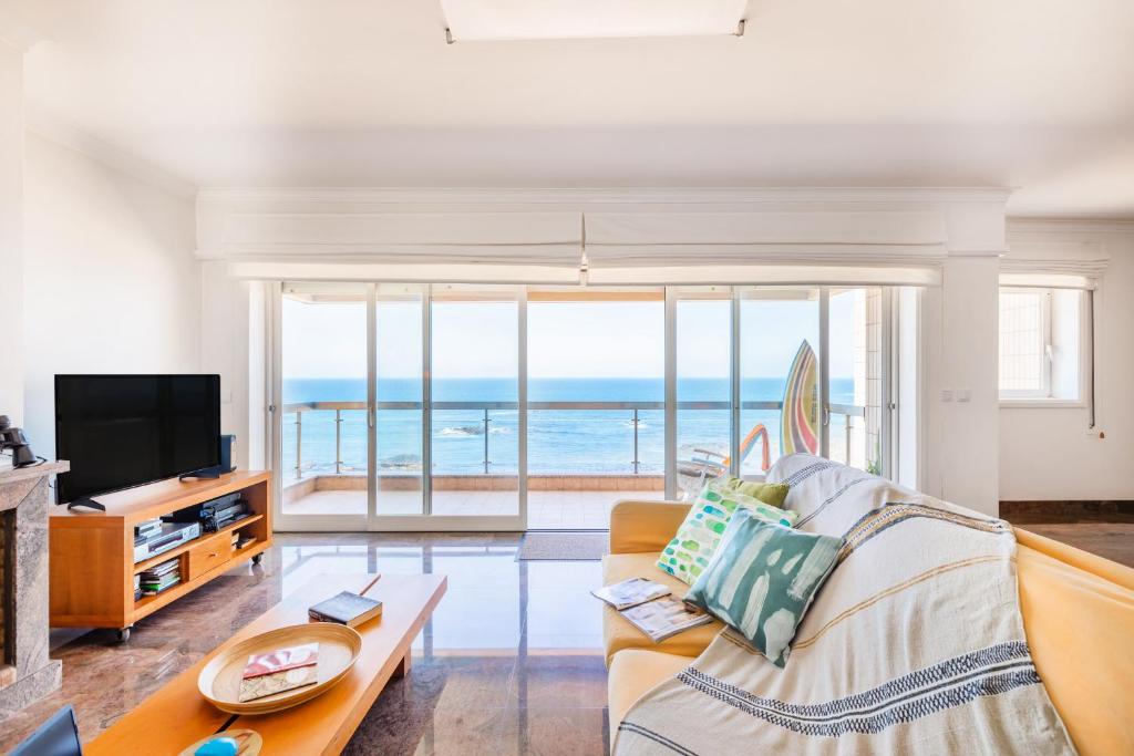 a living room with a couch and a view of the ocean at Povoa Sunset Views in Póvoa de Varzim