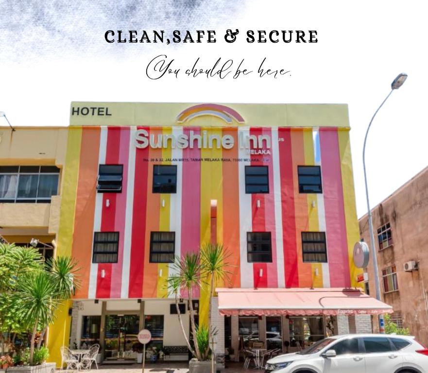un edificio colorido con un coche aparcado delante de él en Sunshine Inn Plus, en Melaka