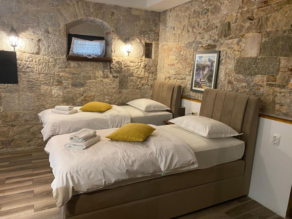 Habitación con 2 camas y paredes de piedra. en Elena Rooms, en Split