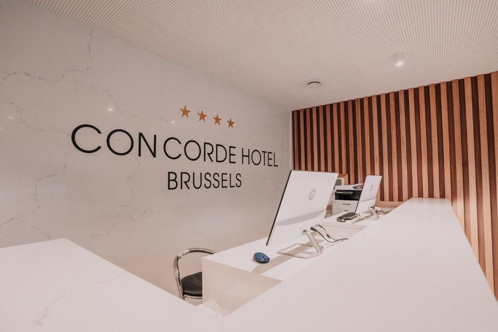布魯塞爾的住宿－Hôtel Concorde，墙上有两张桌子和一个标志的办公室