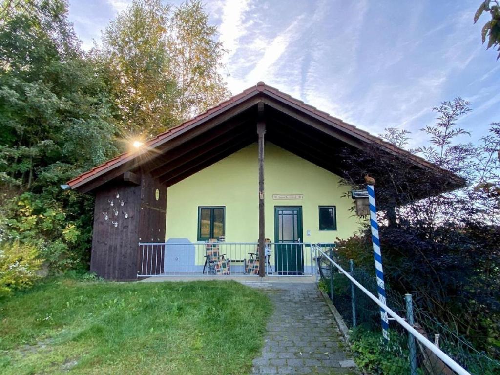 una pequeña casa amarilla con porche en Haus Fernblick, en Waldkirchen