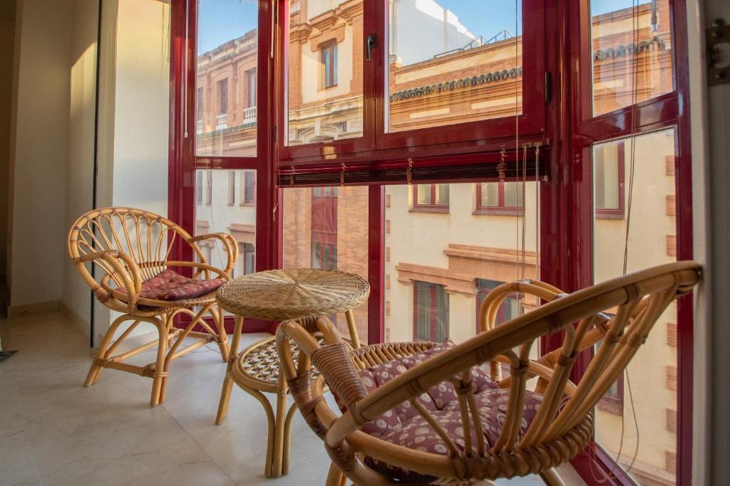 une chambre avec des chaises, une table et une grande fenêtre dans l'établissement Apartamento Nuestra Andalucia - Cadiz Centro - parking, à Cadix