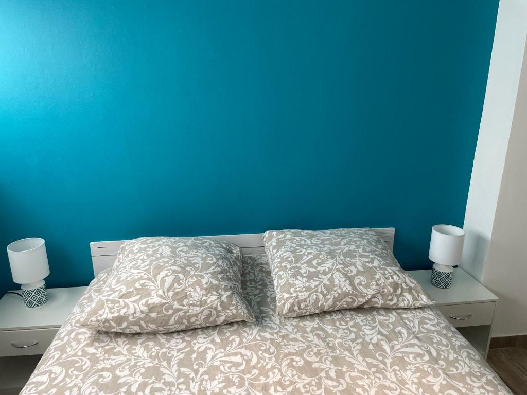 een bed met 2 kussens en een blauwe muur bij Appartement 13008 bord de mer in Marseille