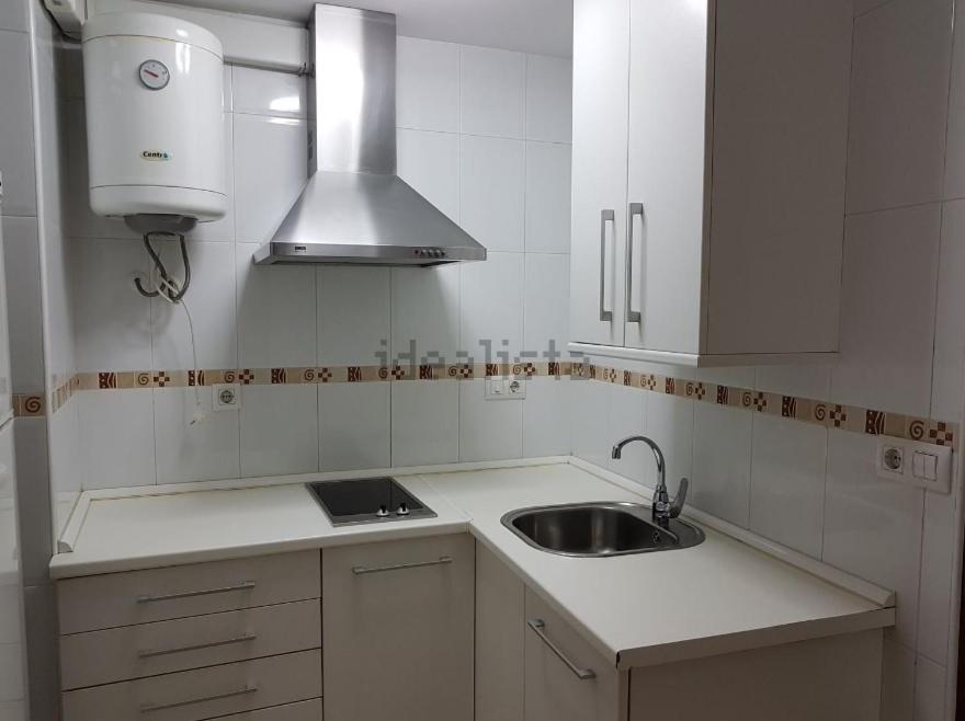 Una cocina blanca con fregadero y estufa. en Italia 57, en Huelva
