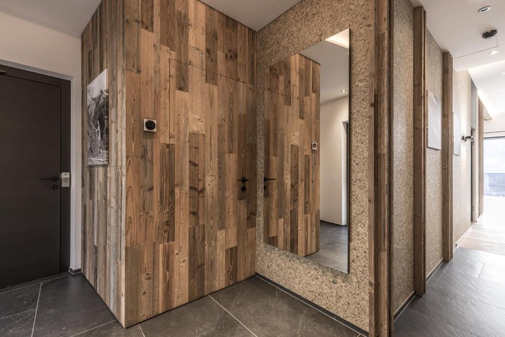 a hallway with wooden walls and a mirror at Perfect Lodgings Panorama in Hart im Zillertal