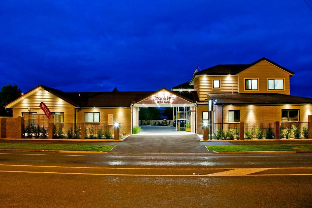 uma casa com um sinal na frente dela em Brooklyn Motor Lodge em Hamilton