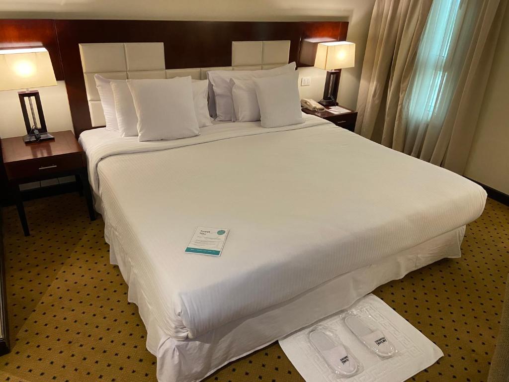 a large white bed in a hotel room at Barceló Cairo Pyramids in Cairo