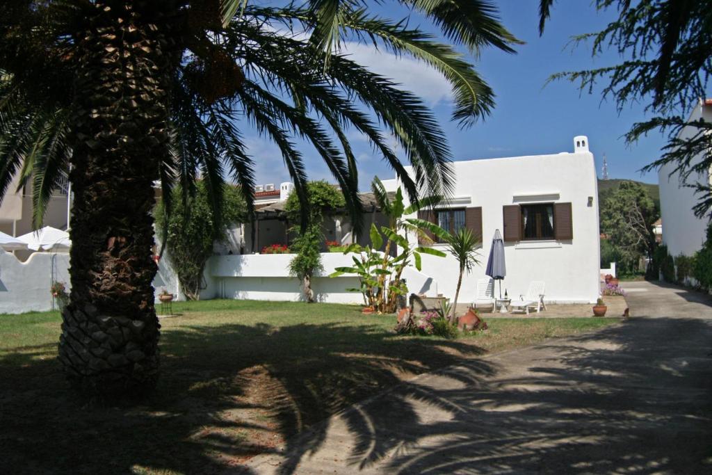 una casa con una palmera delante de ella en Villa Paradiso, en Neos Marmaras
