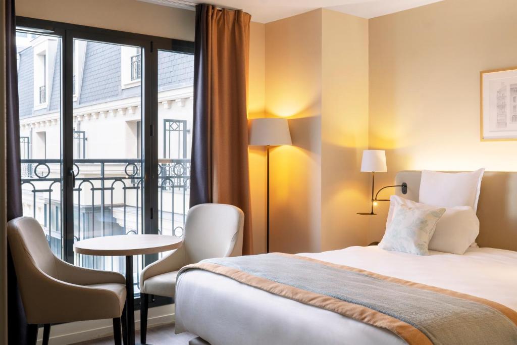 una camera d'albergo con letto, tavolo e finestra di Residhome Paris Clamart a Clamart