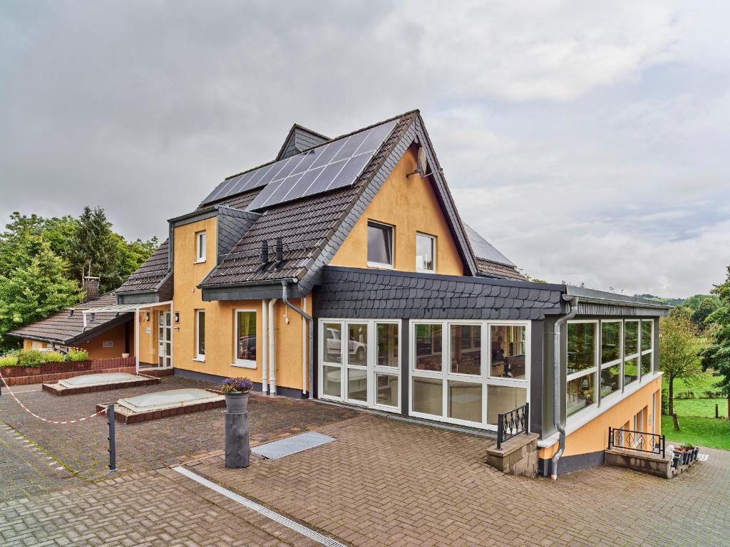 une maison avec des panneaux solaires sur le toit dans l'établissement Haus Eifelsonne, à Hellenthal