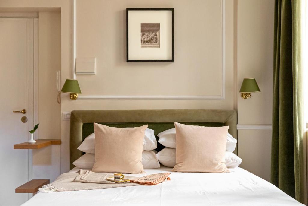 ein Schlafzimmer mit einem Bett mit weißen Laken und Kissen in der Unterkunft Casa Cucu Piazza del Popolo in Rom