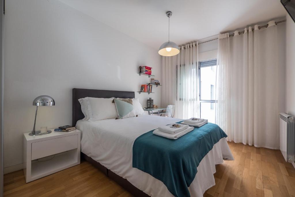 a bedroom with a large bed with a blue blanket at Flamingos - 81258AL in Lisbon