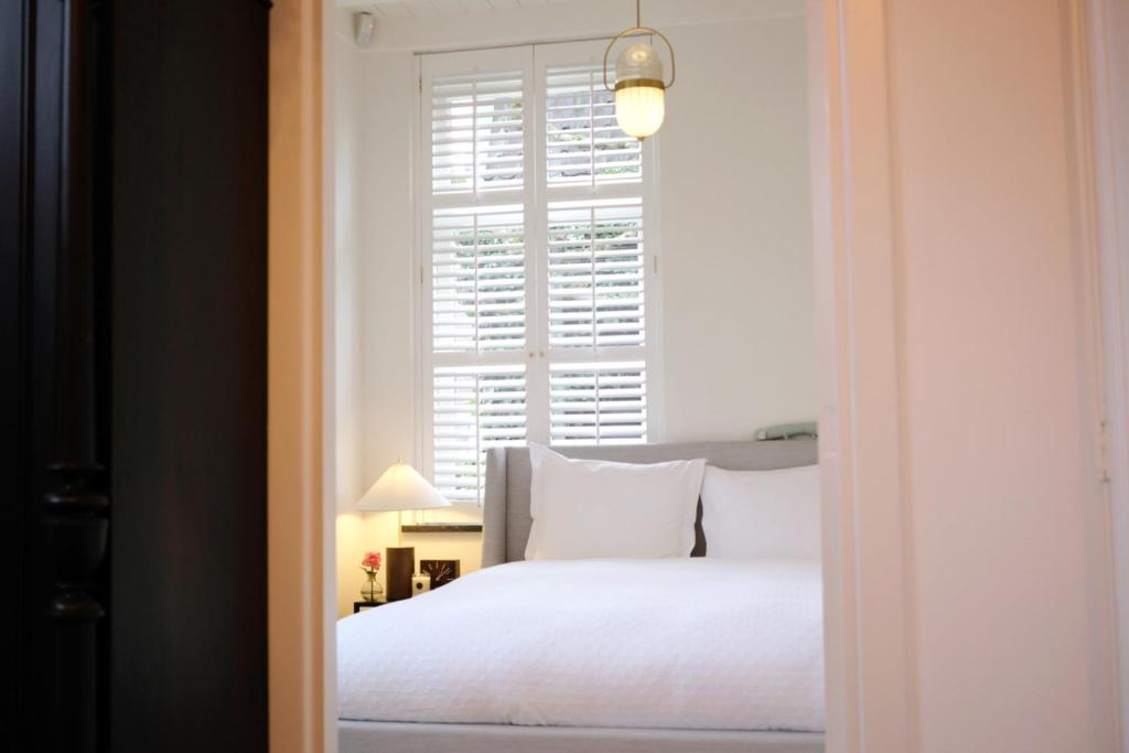 a bedroom with a white bed and a window at La Vie en Roos Amerongen in Amerongen