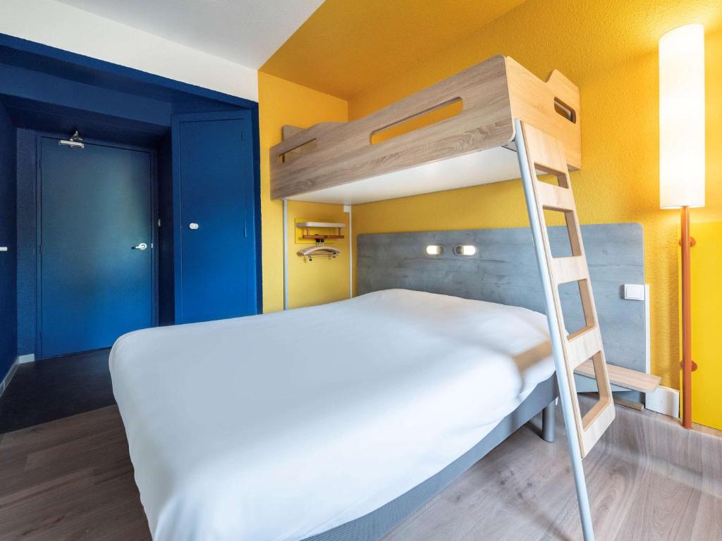 een stapelbed in een kamer met een ladder bij ibis budget Nimes Caissargues in Caissargues
