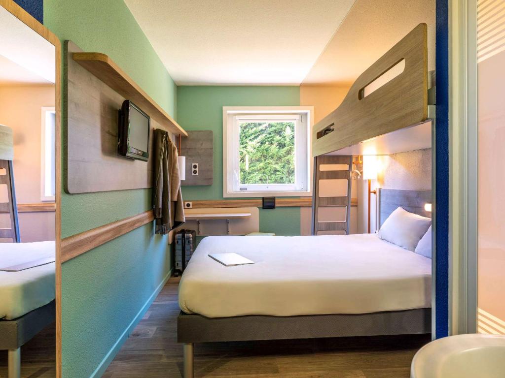 Postel nebo postele na pokoji v ubytování Ibis Budget Lyon Est Saint Quentin Fallavier