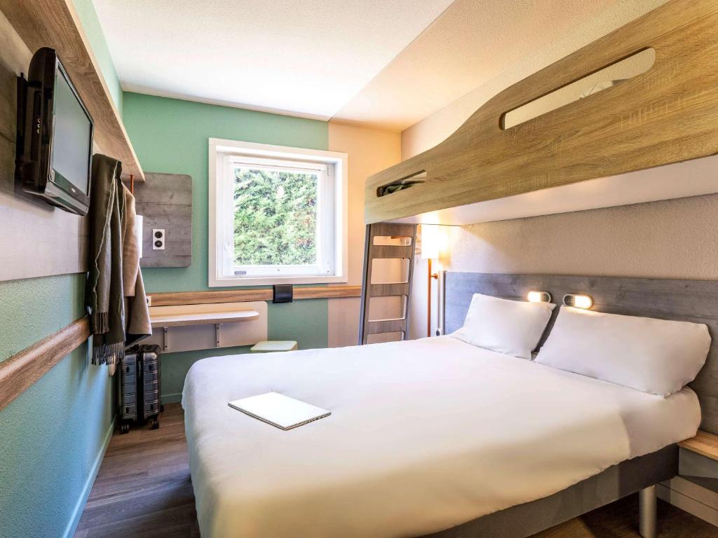 Postel nebo postele na pokoji v ubytování Ibis Budget Lyon Est Saint Quentin Fallavier